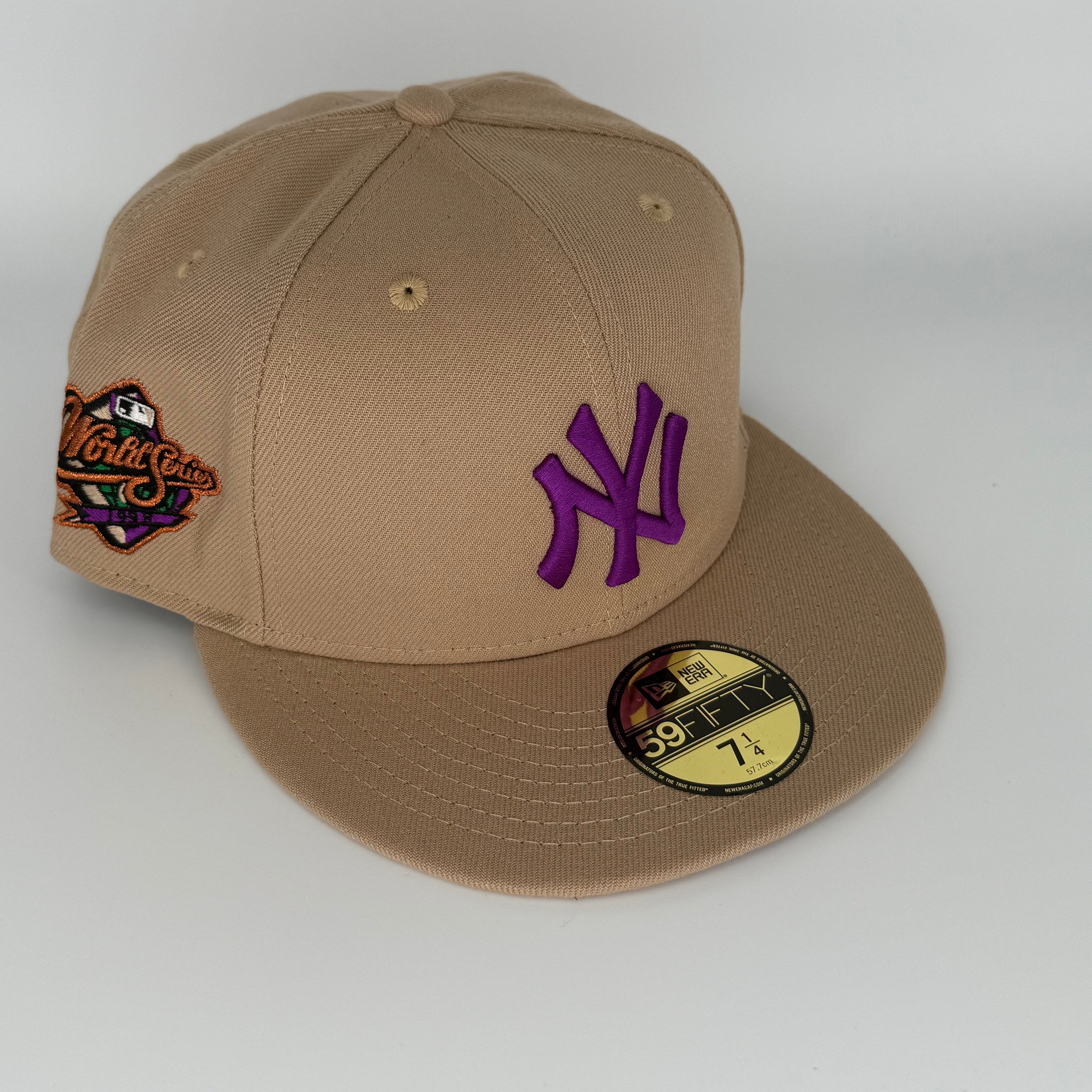 Beige cap with purple logo and patch on a white background