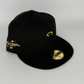 Black cap with gold embroidery on a gray background